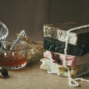 A stack of rustic handmade soap bars with natural ingredients and honey in a cozy setting.